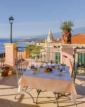 Taormina Sicily Italy breakfast table with a rooftop view over Taormina breakfast with coffee bread and fruit