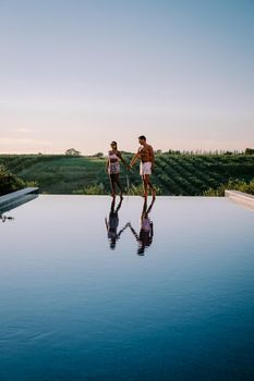 Luxury resort with a view over the wine field in Selinunte Sicily Italy. infinity pool with a view over wine fields in Sicilia, a couple on luxury vacation at the Island of Sicily Italy