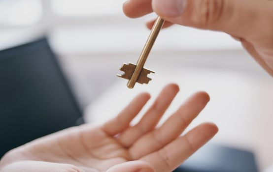 handing the key from hand to hand in the office business finance work documents desk. High quality photo