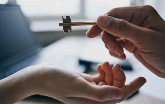 handing the key from hand to hand in the office business finance work documents desk. High quality photo