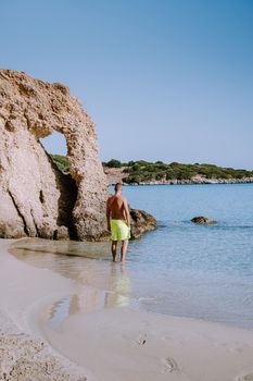 Tropical beach of Voulisma beach, Istron, Crete, Greece ,Most beautiful beaches of Crete island -Istron bay near Agios Nikolaos , young guy mid age on vacation Crete at the beach