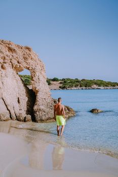 Tropical beach of Voulisma beach, Istron, Crete, Greece ,Most beautiful beaches of Crete island -Istron bay near Agios Nikolaos , young guy mid age on vacation Crete at the beach