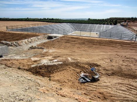 farm reservoir for field irrigation under construction on spanish farmland