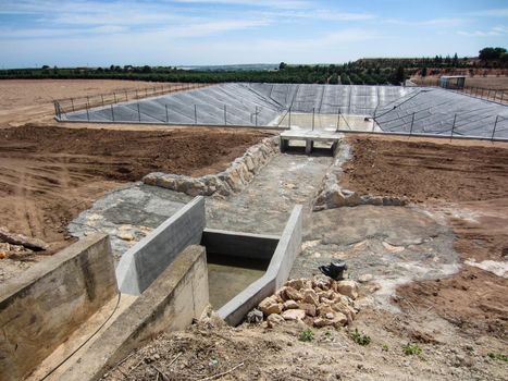 farm reservoir for field irrigation under construction on spanish farmland