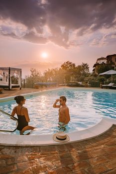 Luxury country house with swimming pool in Italy. Pool and old farm house during sunset central Italy. Couple on Vacation at luxury villa in Italy, men and woman watching sunset