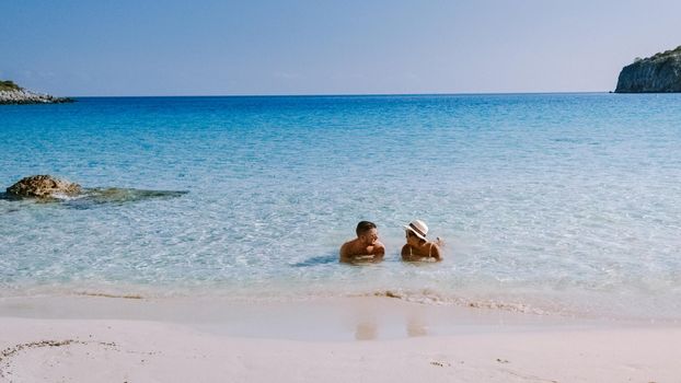 Tropical beach of Voulisma beach, Istron, Crete, Greece ,Most beautiful beaches of Crete island -Istron bay near Agios Nikolaos young couple mid age on vacation in Greece Crete