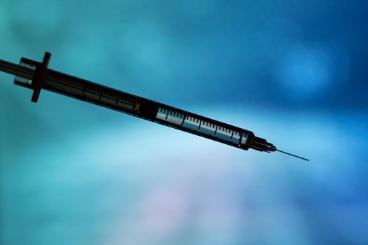 Medical syringe for a vaccine. Blue background