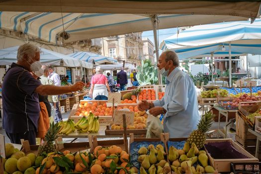 Ortigia in Syracuse Sicily Italy October 2020 in the Morning. Travel Photography from Syracuse, Italy on the island of Sicily. Cathedral Plaza and market with people wearing face protection during the 2020 pandemic covid 19 corona virus