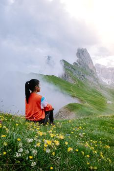 woman on vacation hiking in the Italien Dolomites, Amazing view on Seceda peak. Trentino Alto Adige, Dolomites Alps, South Tyrol, Italy, Europe. Odle mountain range, Val Gardena. Majestic Furchetta peak in morning sunlight. Italy