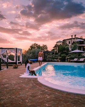 Luxury country house with swimming pool in Italy. Pool and old farm house during sunset central Italy. Couple on Vacation at luxury villa in Italy, men and woman watching sunset