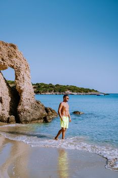 Tropical beach of Voulisma beach, Istron, Crete, Greece ,Most beautiful beaches of Crete island -Istron bay near Agios Nikolaos , young guy mid age on vacation Crete at the beach