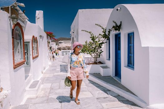 Sunset at the Island Of Santorini Greece, beautiful whitewashed village Oia with church and windmill during sunset, streets of Oia Santorini during summer vacation at the Greek Island Woman on luxury vacation Greece