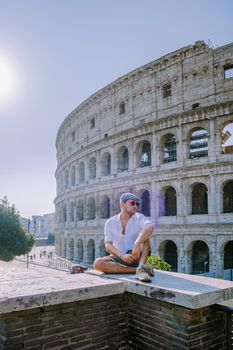 View of Colosseum in Rome and morning sun, Italy, Europe. young guy on city trip Rome