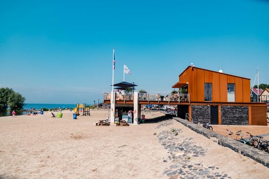 Urk Netherlands August 2020, harbor and lighthouse near the beach on a bright summer day Flevoland Urk Netherlands Europe, new restaurant pavilion on the beach