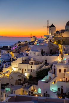 Sunset at the Island Of Santorini Greece, beautiful whitewashed village Oia with church and windmill during sunset, streets of Oia Santorini during summer vacation at the Greek Island