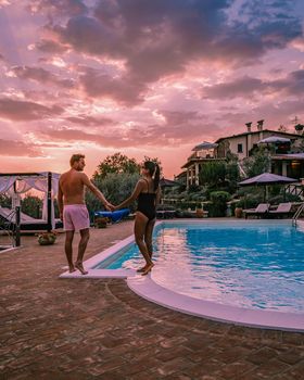 Luxury country house with swimming pool in Italy. Pool and old farm house during sunset central Italy. Couple on Vacation at luxury villa in Italy, men and woman watching sunset