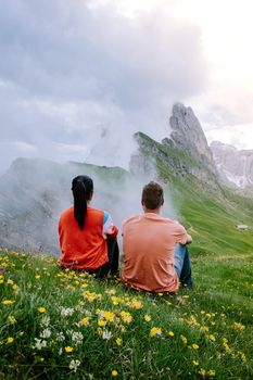 couple on vacation hiking in the Italien Dolomites, Amazing view on Seceda peak. Trentino Alto Adige, Dolomites Alps, South Tyrol, Italy, Europe. Odle mountain range, Val Gardena. Majestic Furchetta peak in morning sunlight. Italy