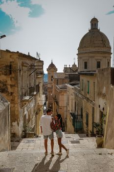 Sicily Italy, view of Noto old town and Noto Cathedral, Sicily, Italy. beautiful and typical streets and stairs in the baroque town of Noto in the province of Syracuse in Sicily, a couple on city trip Noto