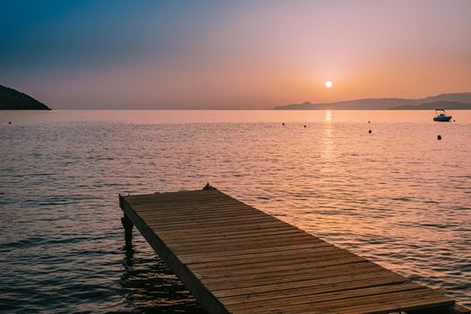  wooden pier at the beach in sunrise time with golden sky. Vacation and travel concept. Crete Greece