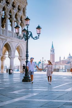 couple on a city trip in Venice, view of piazza San Marco, Doge's Palace Palazzo Ducale in Venice, Italy. Architecture and landmark of Venice. Sunrise cityscape of Venice Italy