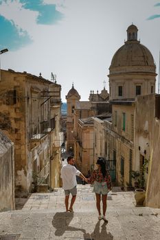 Sicily Italy, view of Noto old town and Noto Cathedral, Sicily, Italy. beautiful and typical streets and stairs in the baroque town of Noto in the province of Syracuse in Sicily, a couple on city trip Noto