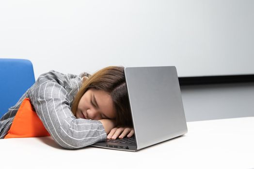 Asian woman is student,businesswoman working by computer notebook, laptop in office meeting room with whiteboard background and nap or sleep for rest because of tired in concept working woman