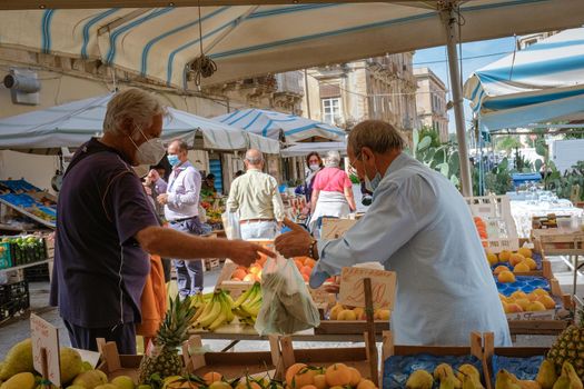 Ortigia in Syracuse Sicily Italy October 2020 in the Morning. Travel Photography from Syracuse, Italy on the island of Sicily. Cathedral Plaza and market with people wearing face protection during the 2020 pandemic covid 19 corona virus