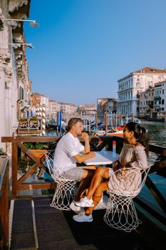 couple men and woman on a city trip to Venice Italy, colorful streets with canals Venice. Europe