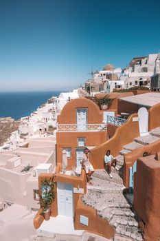 Santorini Island Greece, couple men and woman on vacation at the Greek Island of Santorini visit the white village of Oia Santorini. Greece