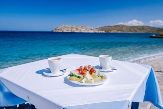 Crete Greece Plaka Lassithi with is traditional blue table and chairs and the beach in Crete Greece. Paralia Plakas, Plaka village Crete