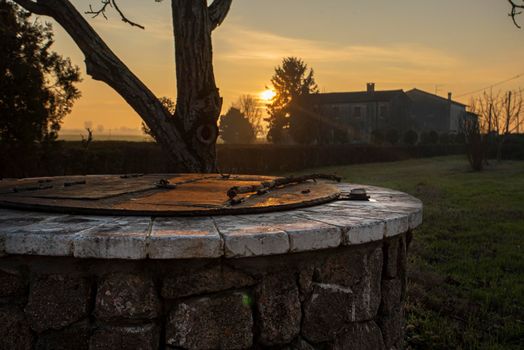 Water Well immersed in a countryside landscape at sunset time