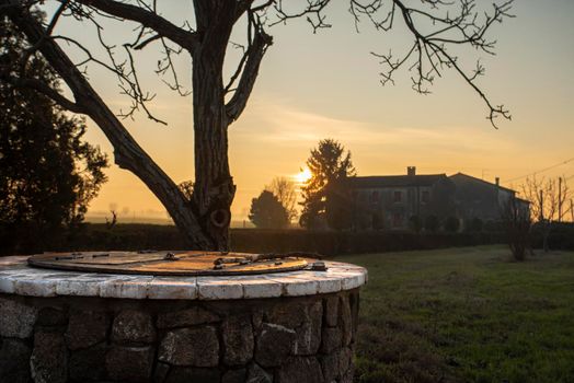 Water Well immersed in a countryside landscape at sunset time
