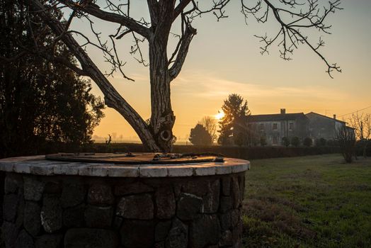 Water Well immersed in a countryside landscape at sunset time