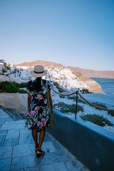 Sunset at the Island Of Santorini Greece, beautiful whitewashed village Oia with church and windmill during sunset, streets of Oia Santorini during summer vacation at the Greek Island