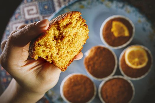 Girl holding fresh cupcake in her hand. Close-up texture of the dough