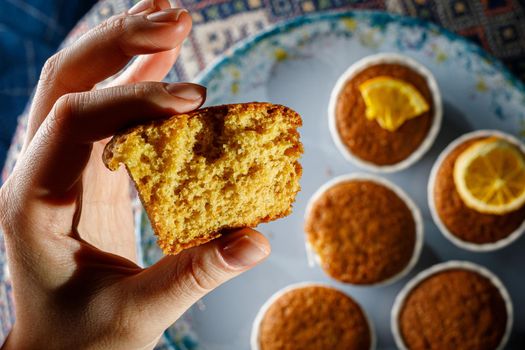 Fresh muffin in a woman's hand. Close-up texture of the dough.