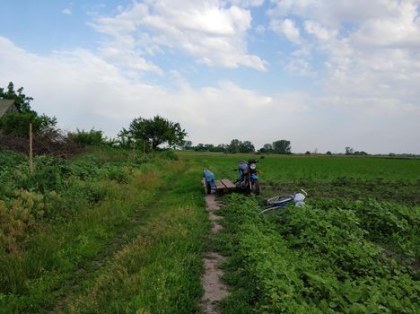 Old motorcycle with a sidecar on a deserted village road in the field. Rural transport.