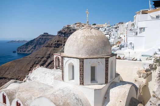 White church at Fira Santorini, Panoramic view of mountains, sea and nature from Fira town, Santorini island Greece. View of the caldera and ships in the bay of Santorini