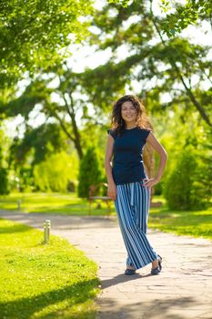 Portrait of young beautiful brunette enjoy bright summer day in green park.