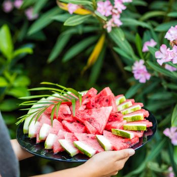 Woman holding watermelon with green background