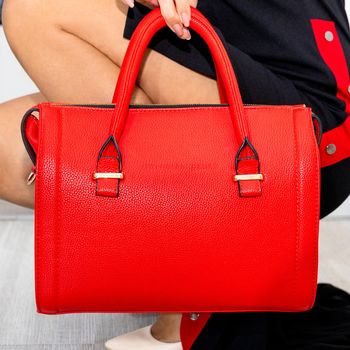 Woman holding beautiful red bag close up
