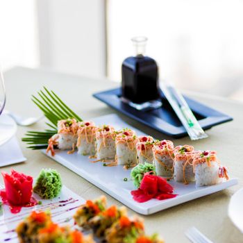 Sushi Set nigiri and sushi rolls with sauce served on white plate on the restaurant table