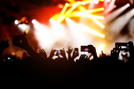 Crowd at a concert. Hands and smartphones in front of the stage