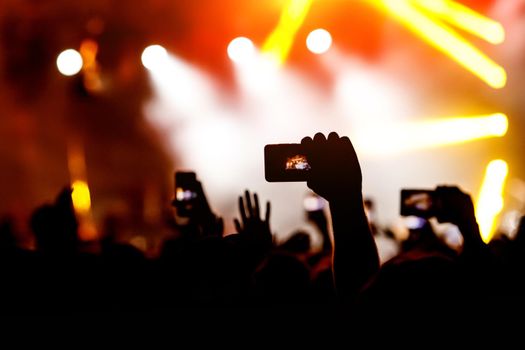 Crowd at a concert. Hands and smartphones in front of the stage