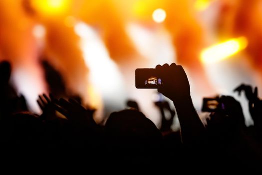 Crowd at a concert. Hands and smartphones in front of the stage