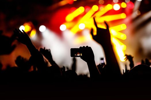 Crowd at a concert. Hands and smartphones in front of the stage