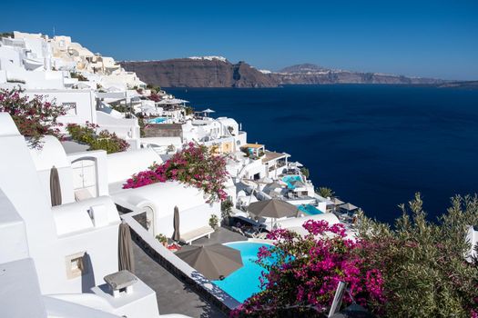 Sunset at the Island Of Santorini Greece, beautiful whitewashed village Oia with church and windmill during sunset, streets of Oia Santorini during summer vacation at the Greek Island