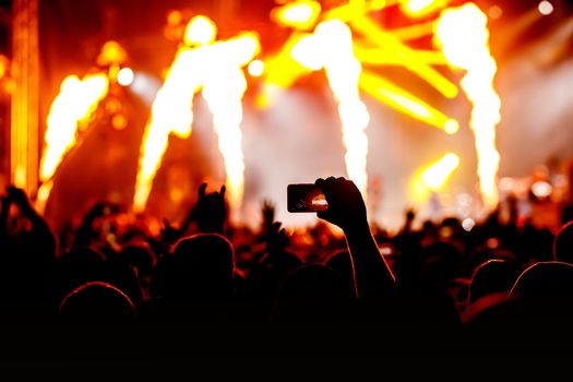 Crowd at a concert. Hands and smartphones in front of the stage