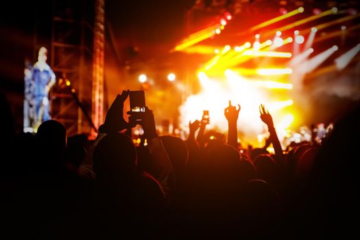 Crowd at a concert. Hands and smartphones in front of the stage