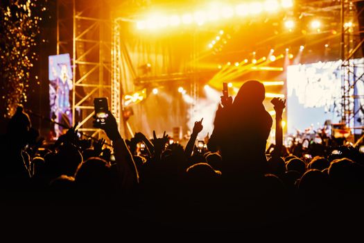 Crowd at a concert. Hands and smartphones in front of the stage